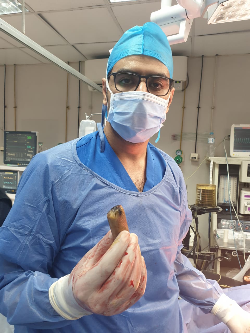 A doctor holding the wrapped phone extracted from a man