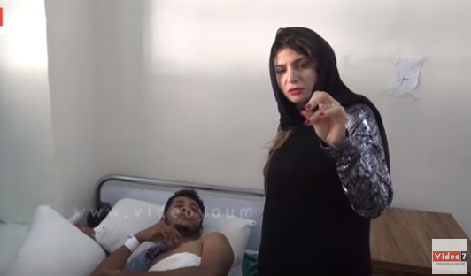المحررة ممسكة بإحدى الشظايا المستخرجة من جسد أحد الجرحى فى مستشفى باصهيب